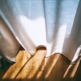 White curtains and sunlight gentle on a wood floor