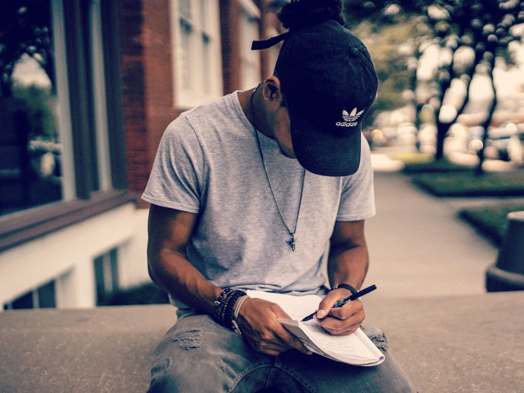 young man writing in a journal