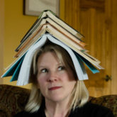 Woman with books stacked on her head.