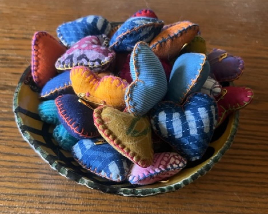 bowl of fabric hearts in varying shades of blue, yellow, and red