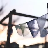 soft-focus photo of prayer flags blowing in a gentle breeze at dawn